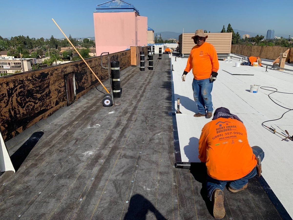 Roofing crew installing a flat commercial roof system in Los Angeles