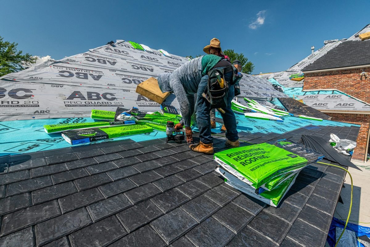 Crew laying synthetic underlayment and shingles on a residential re-roof