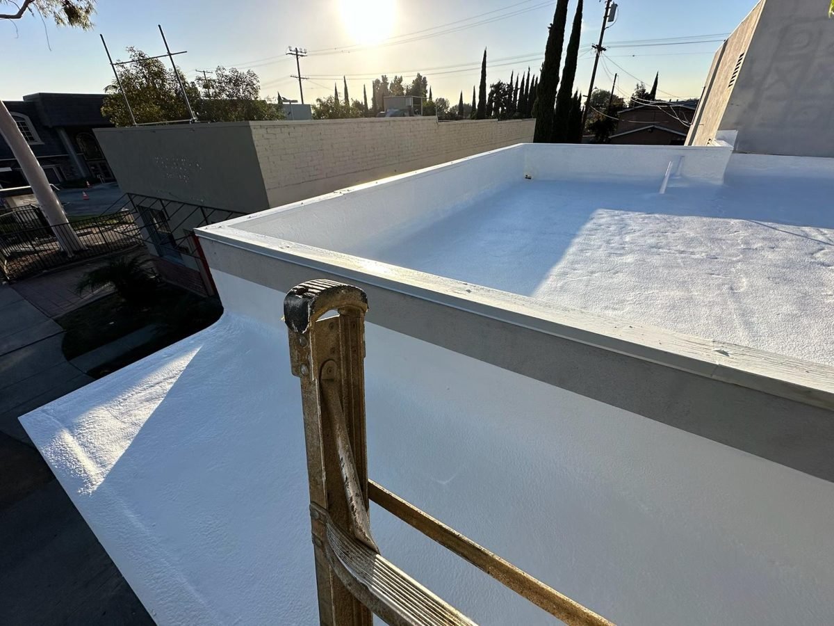Parapet and scupper detail on a low-slope roof after a reflective coating