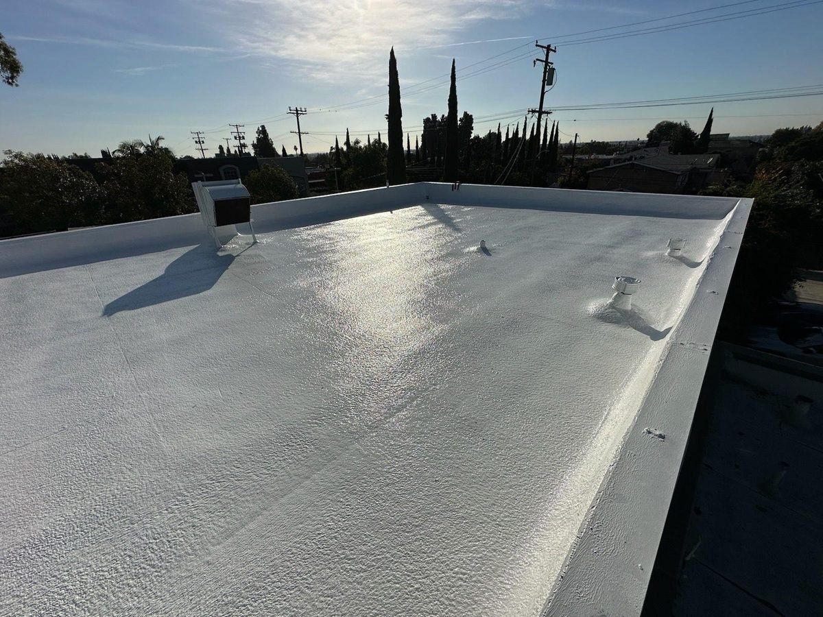 Reflective white roof coating on a low-slope Valley roof at sunset
