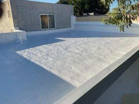 Freshly coated low-slope roof with stucco parapet walls