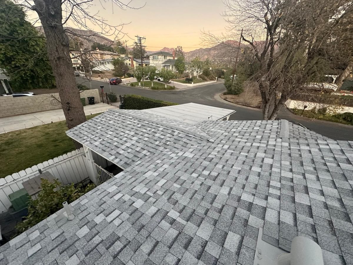Architectural shingle re-roof with new ridge caps on a hillside street