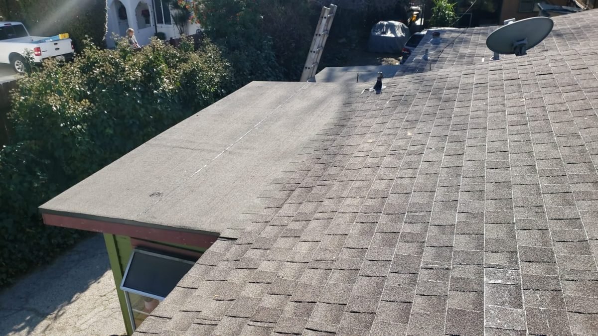 Brown architectural shingle roof over a ranch home on a tree-lined street