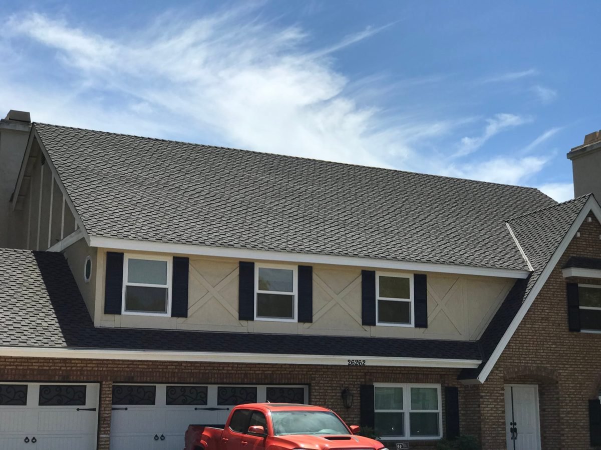 Two-story brick-and-stucco home with a new grey shingle roof